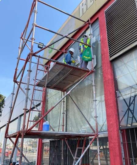 Andamio instalado sobre la fachada de vidrio de un edificio comercial